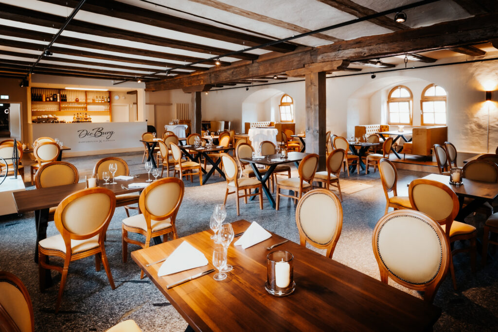 Restaurant mit vielen Tischen und Tresen im Hintergrund